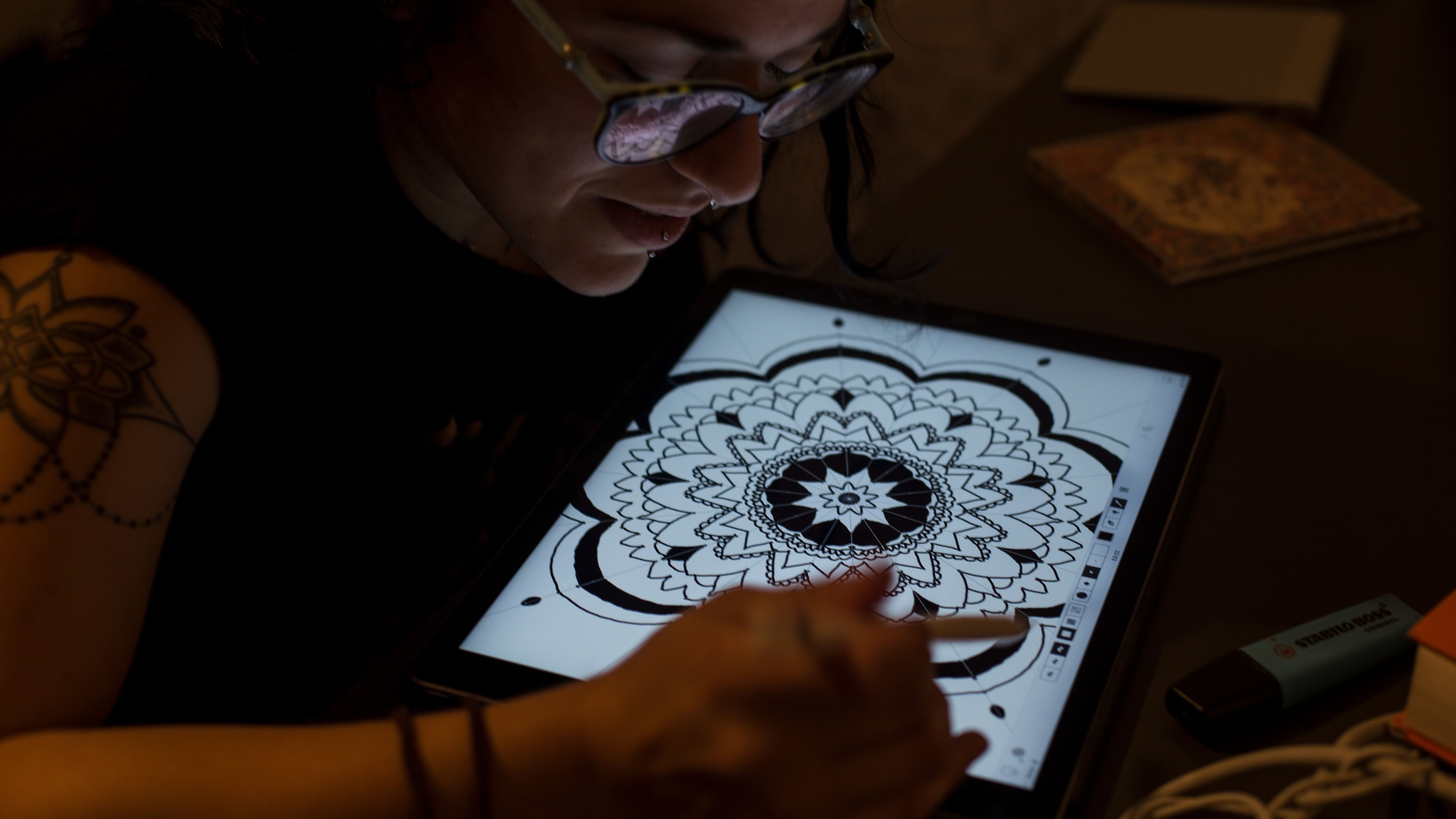 Tatuadora desenhando design de mandala no tablet
